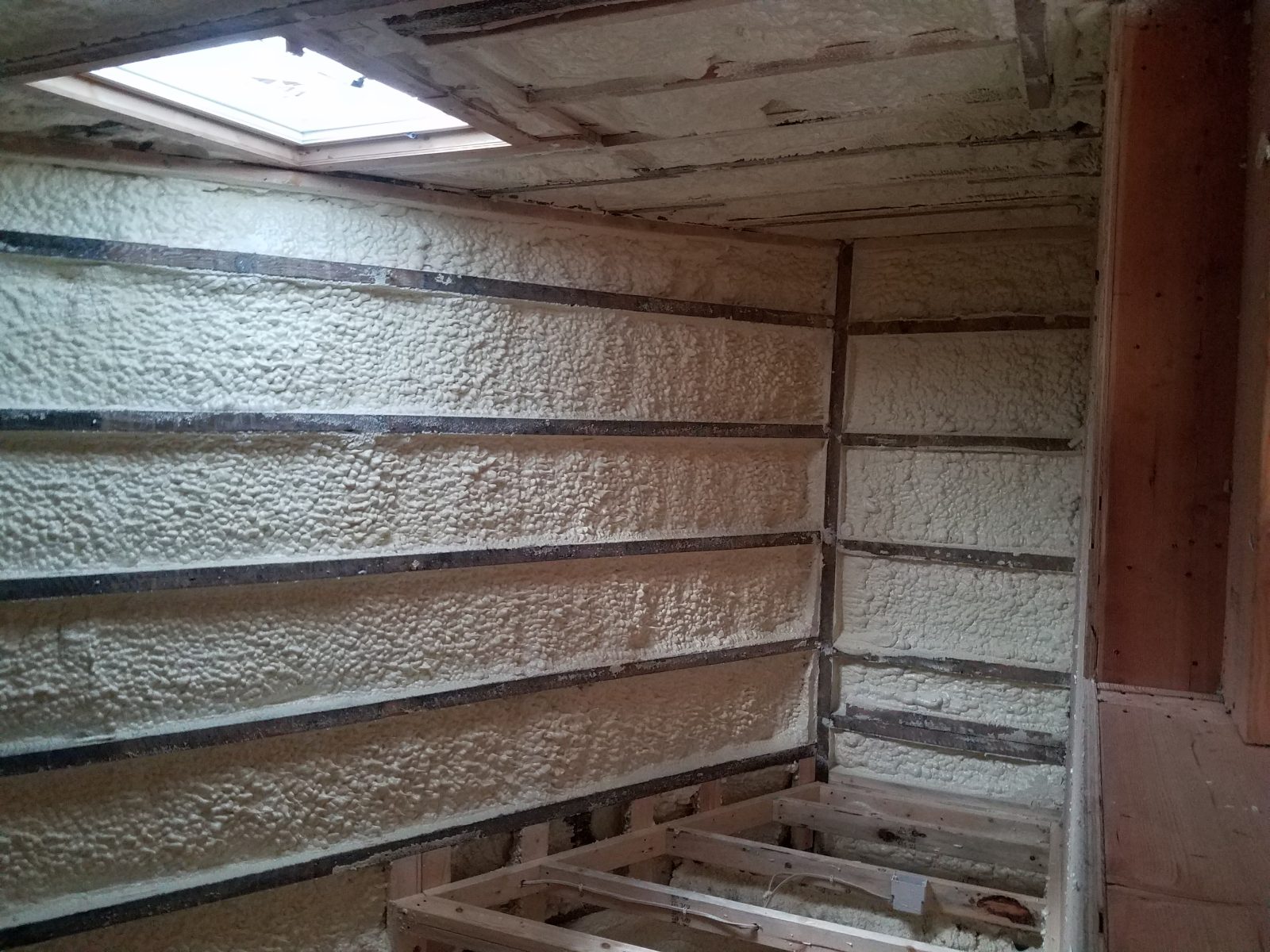 Spray foam being applied to a metal building interior